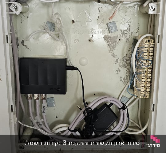 ארון תקשורת ביתי מסודר עם מתג רשת וכבלים מחוברים